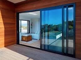 Sliding glass door on a timber deck with a sea view