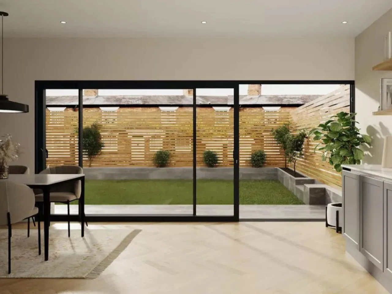 Black slim sliding door between a kitchen and a small walled garden