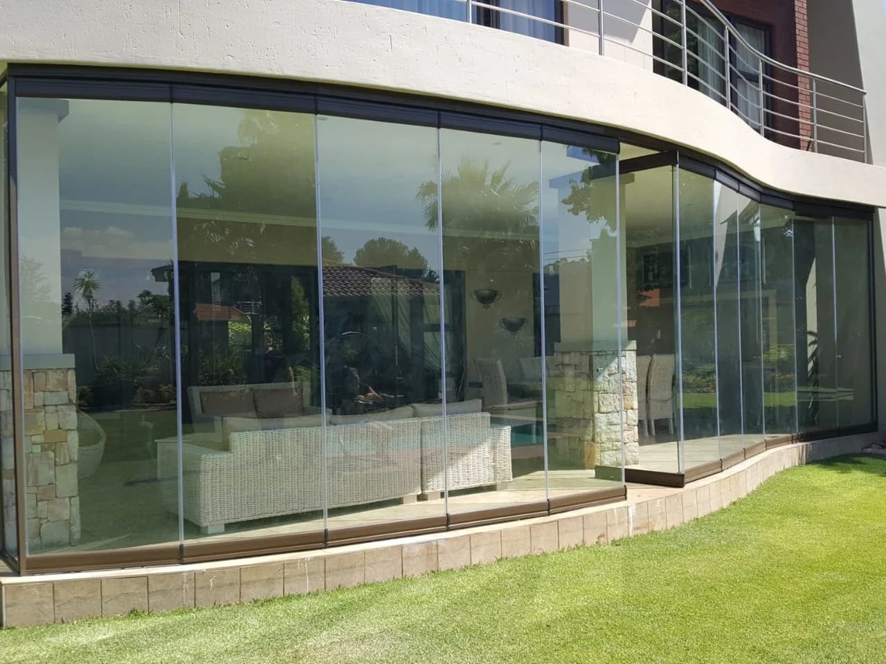 Curved frameless glass enclosure on a modern house
