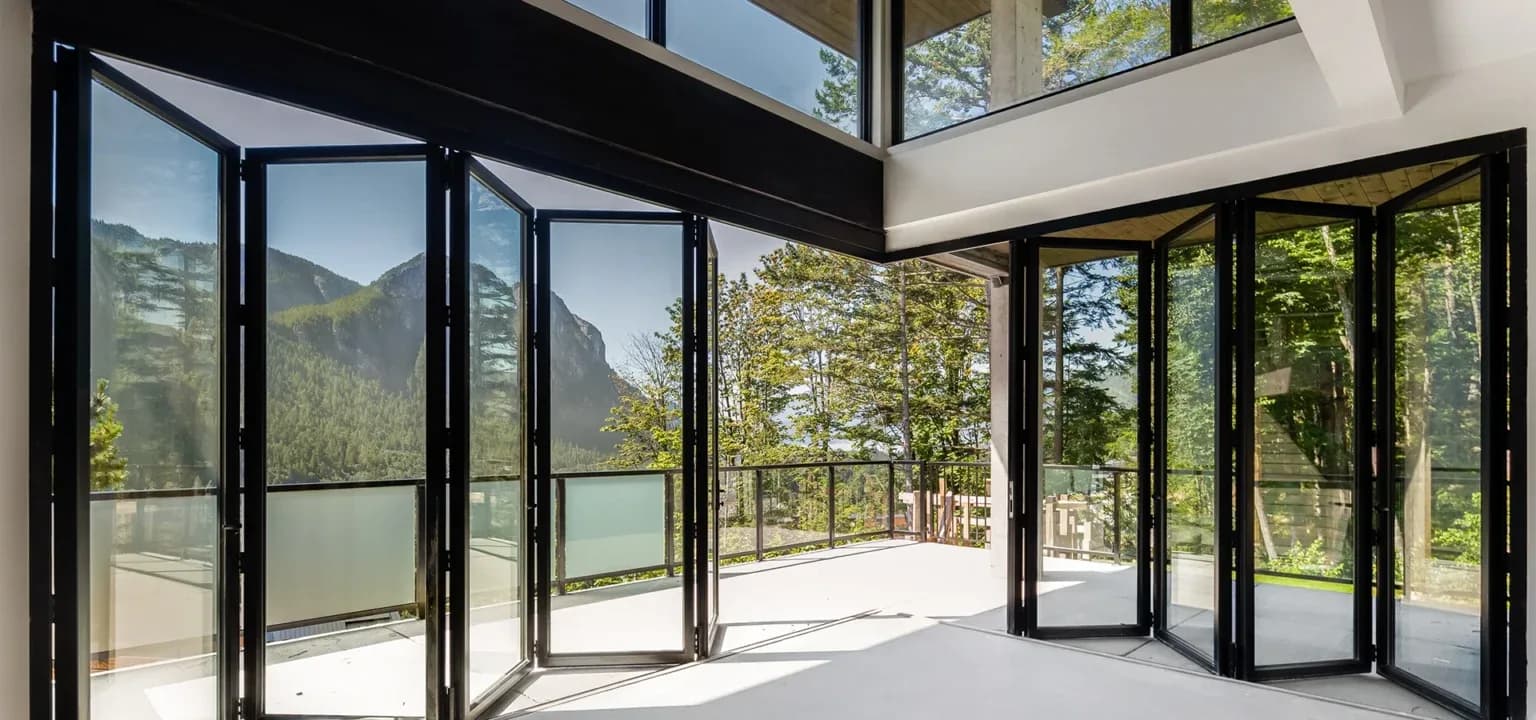 Folding sliding doors fully open on a balcony with a mountain view