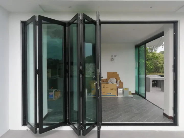 Four-panel aluminium folding door stacked to one side of a bright living room