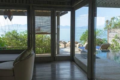 Corner sliding glass doors opening a lounge onto a sea-view terrace
